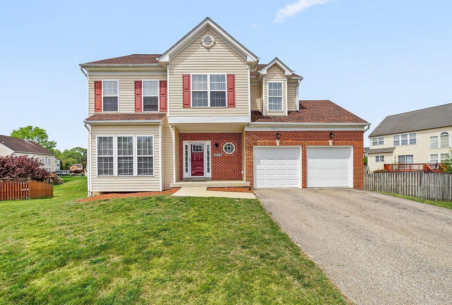 Renovated two-story colonial with brick garage elevation in Clinton, Maryland